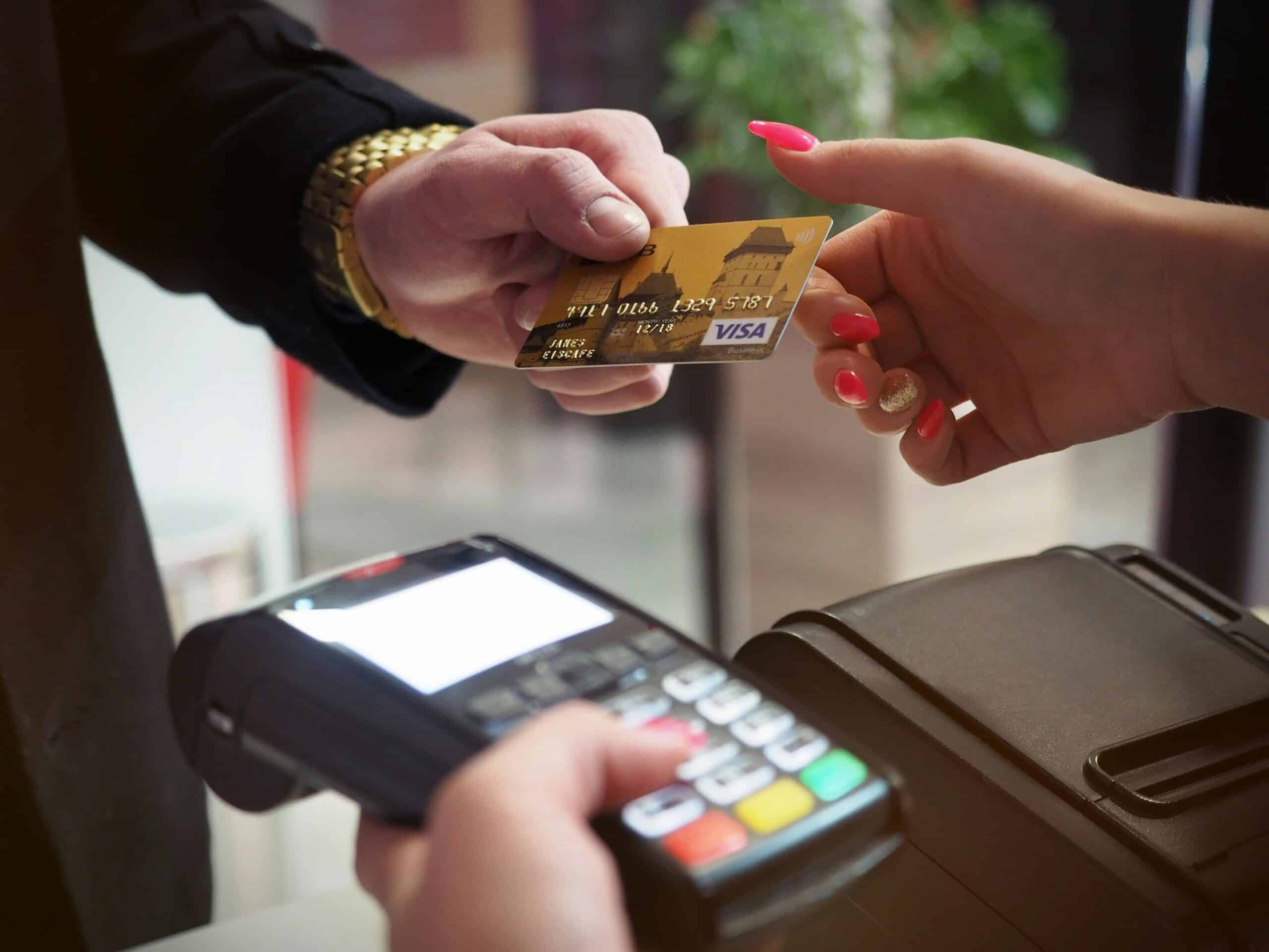 Person Paying With Card by Tapping on Black Payment Terminal